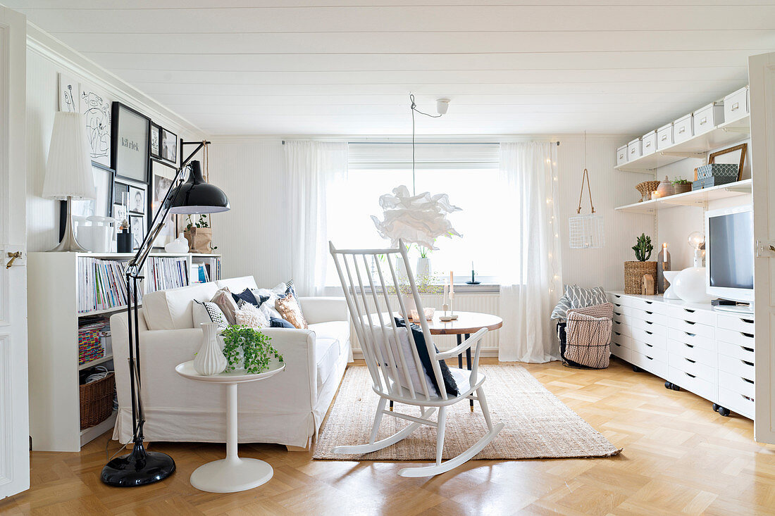 weiße Möbel im hellen Wohnzimmer mit Parkettboden