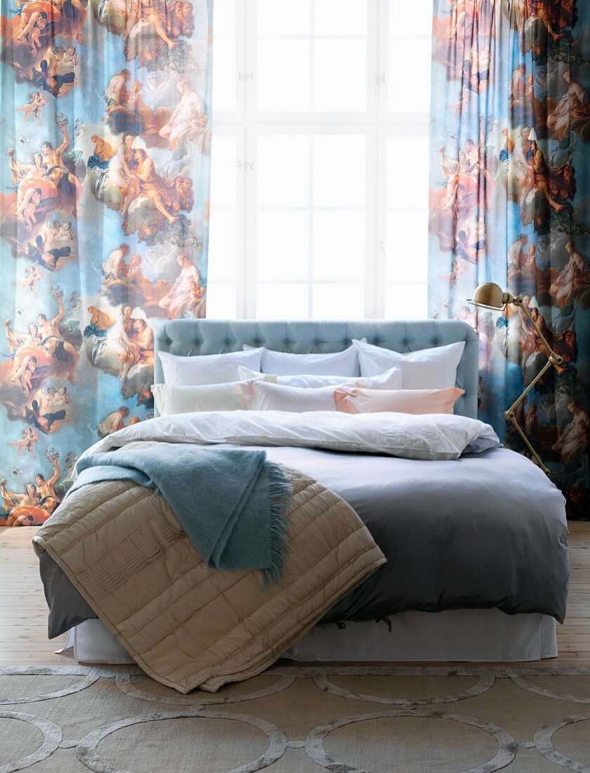 Doppelbett mit Bettwäsche und Decken in Pastelltönen, Vorhang mit Engelmotiven
