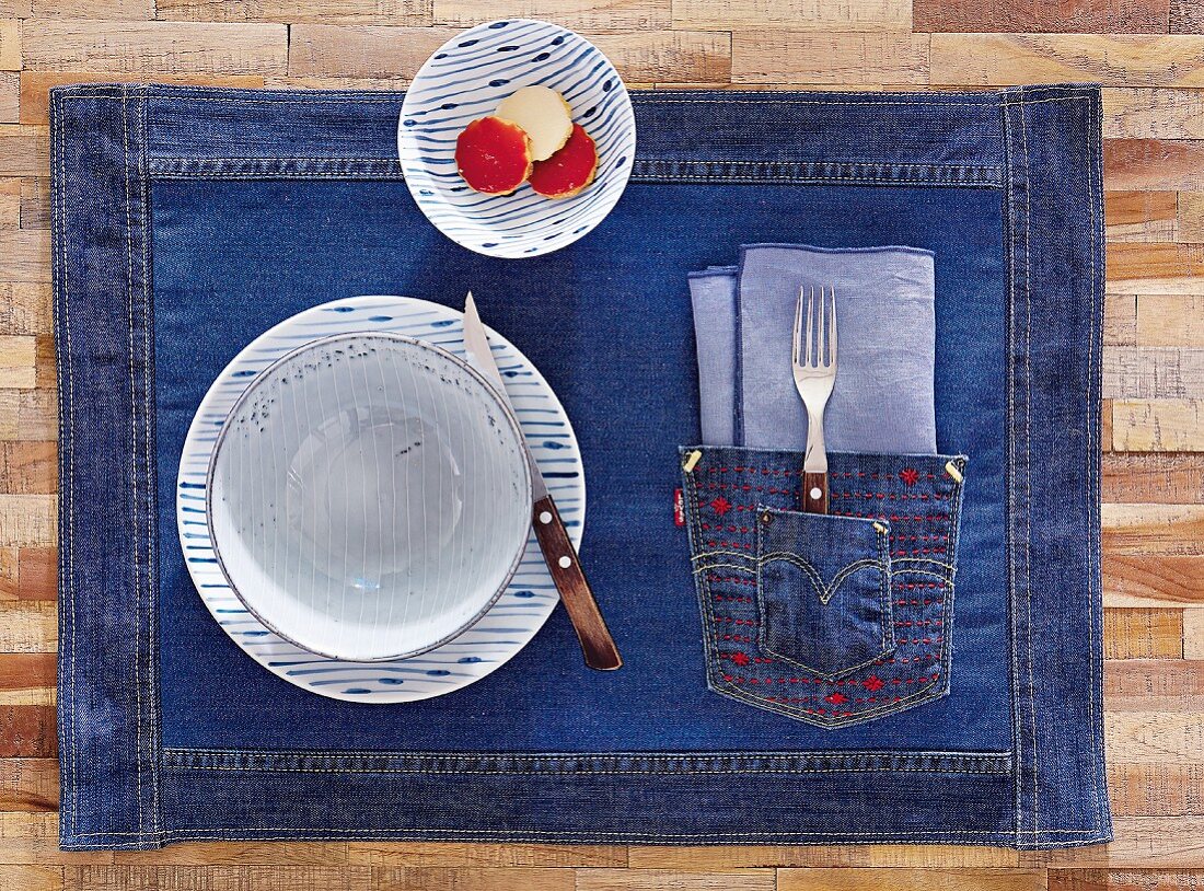 A denim placemat with patch pocket and red stitching