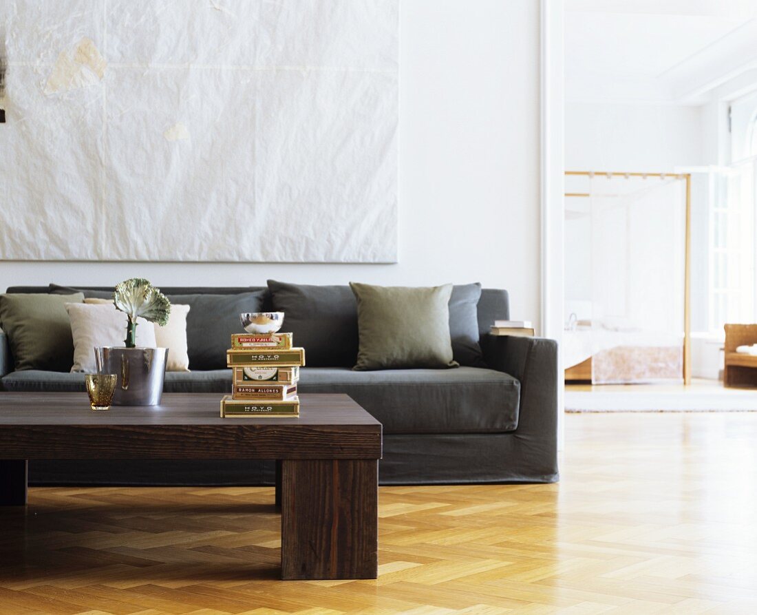 Herringbone parquet floor, coffee table and taupe couch in living room