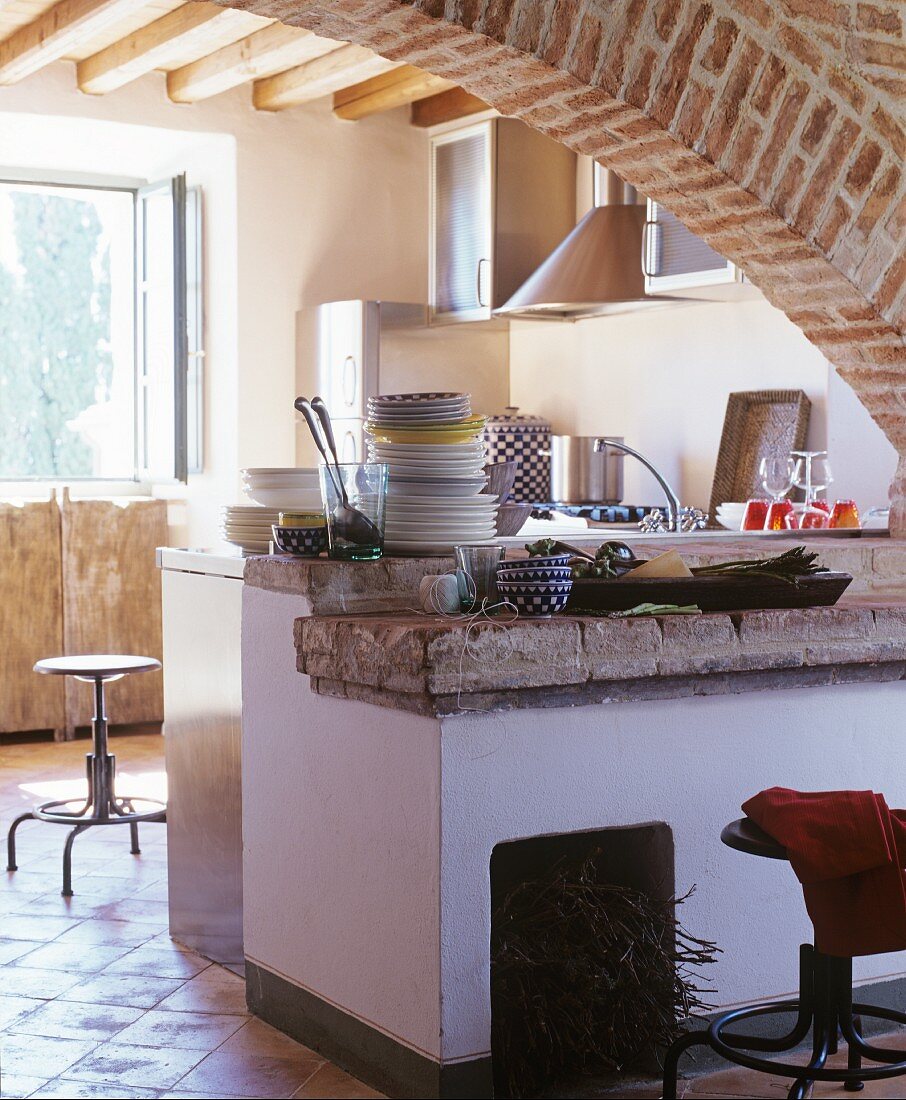 Arch and stone worksurface in rustic kitchen