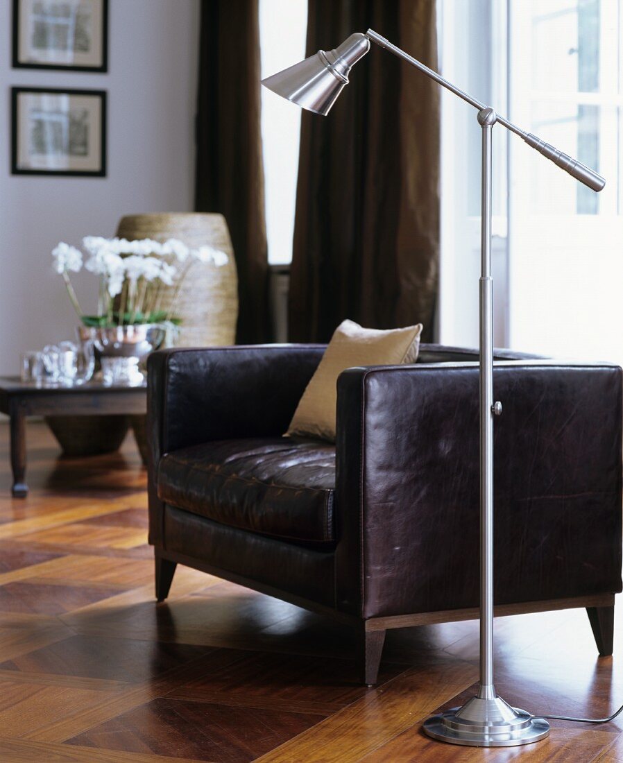 Standard lamp next to dark brown leather armchair