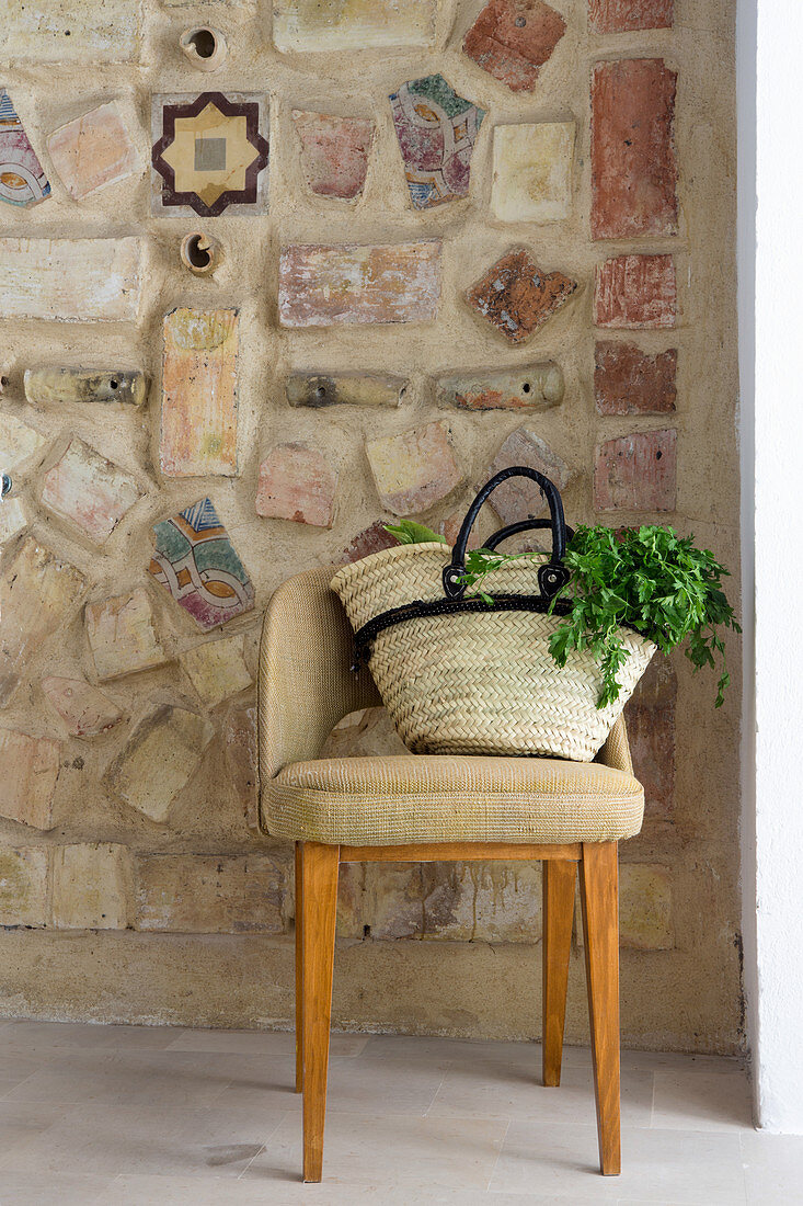 Shopping bag on chair in front of Mediterranean mosaic wall