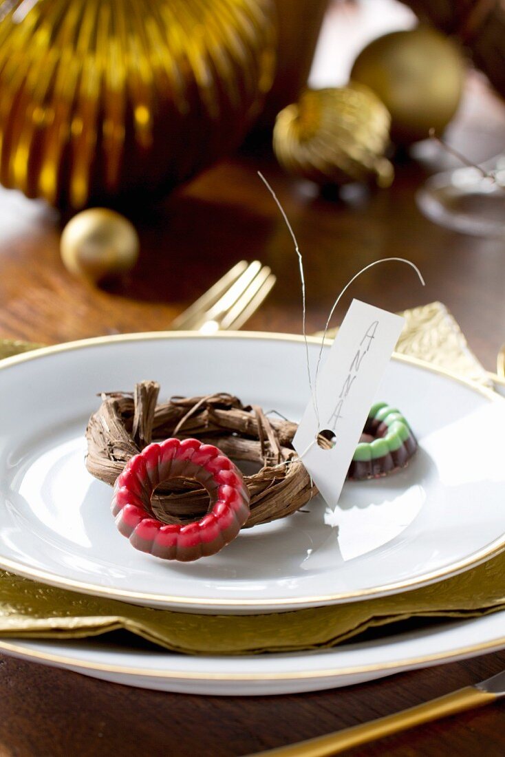 Small chocolate rings and mini wreath used as name tag on plate