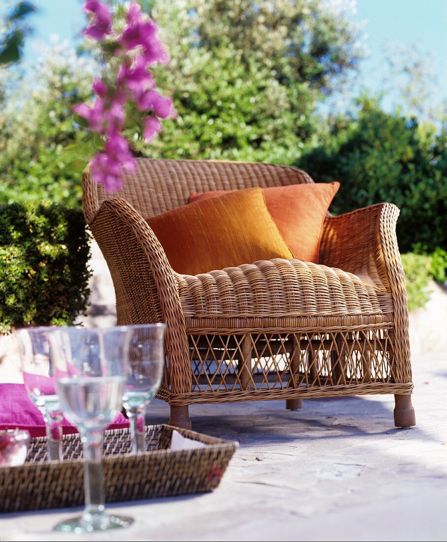 Wicker armchair with cushions on Mediterranean terrace