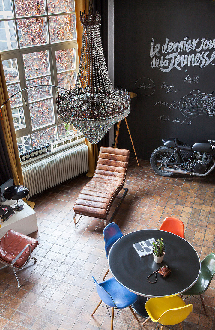 View down into industrial loft apartment with chalkboard wall and designe furniture