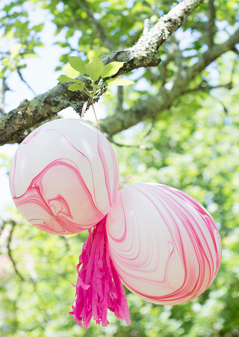 Marmorierte Luftballons am Baum hängend