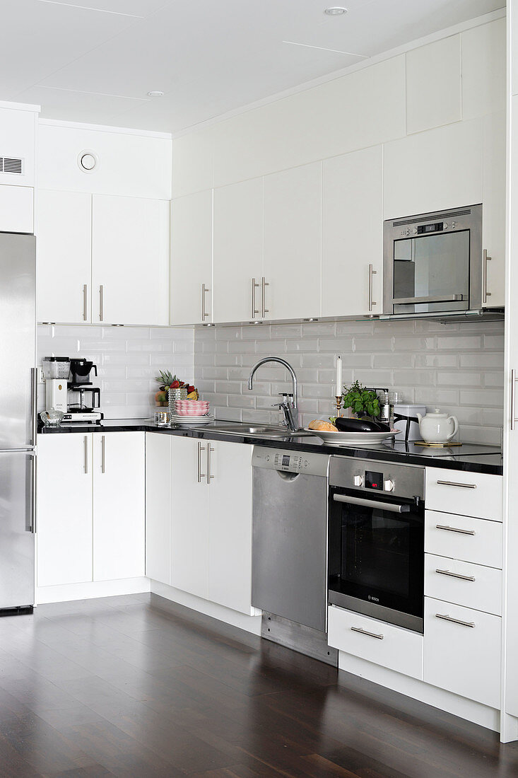 Stainless steel appliances in minimalist kitchen