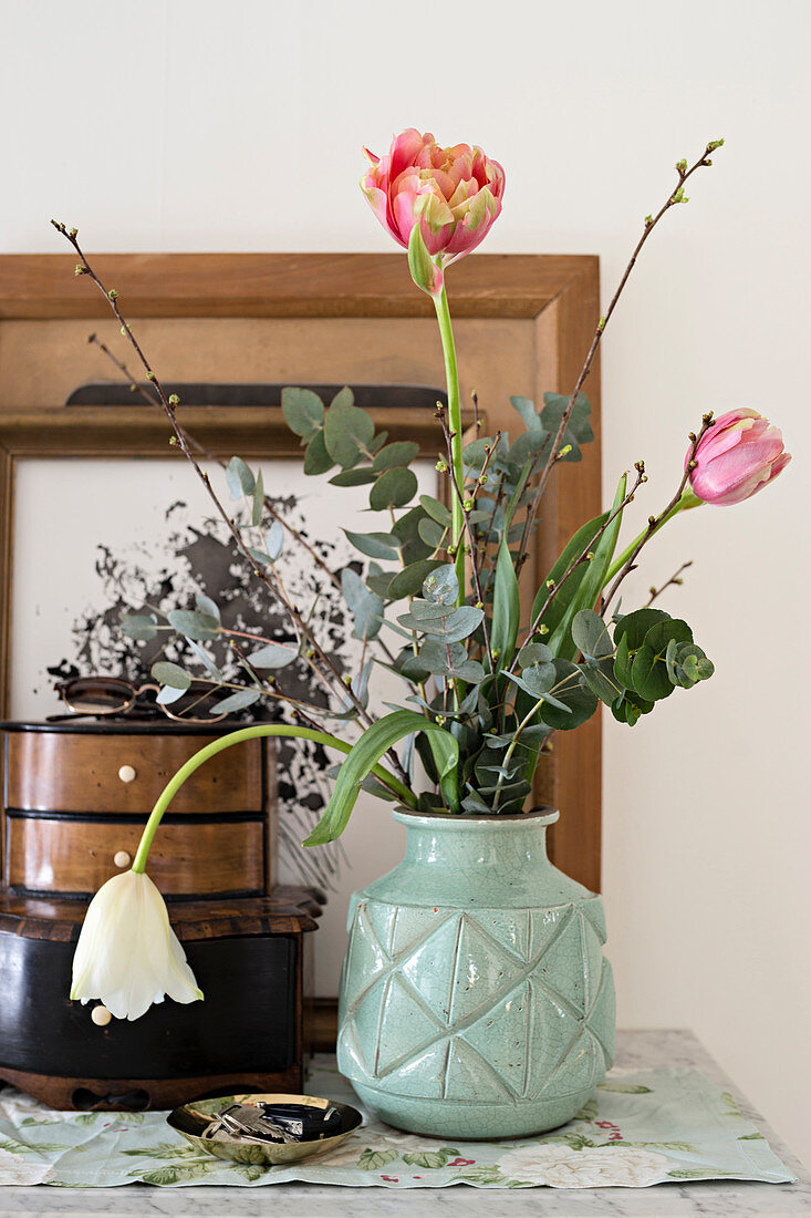 Strauß mit Tulpen, Eukalyptus und Zweigen in einer Vintagevase