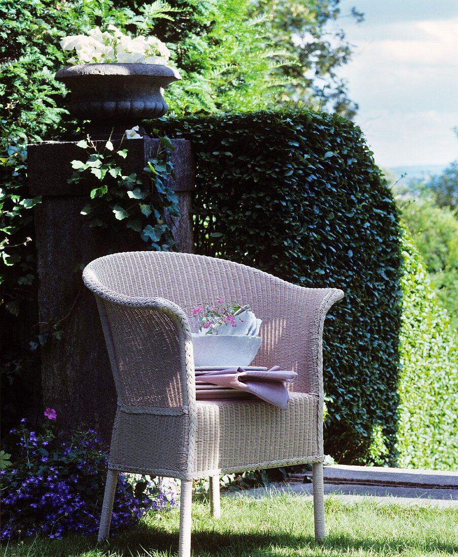 Stacked crockery on wicker chair in classic summer garden