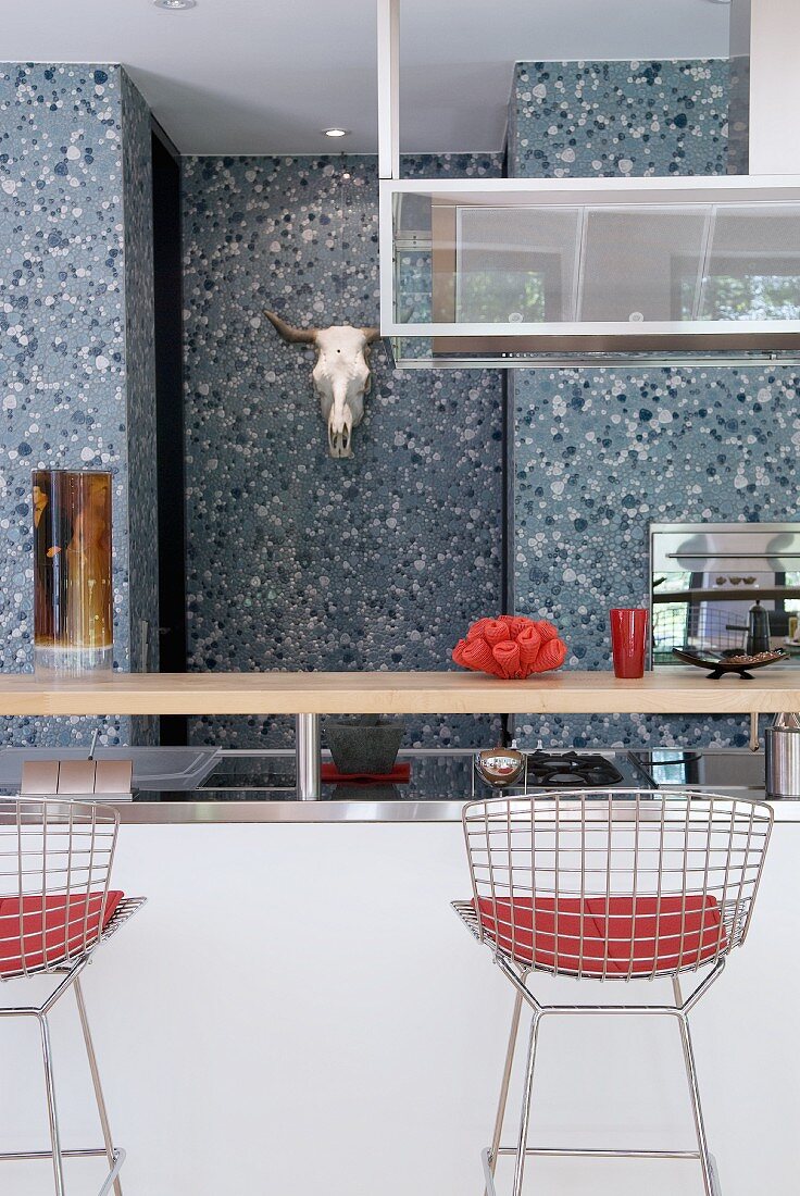 Designer chairs at kitchen counter and speckled wall
