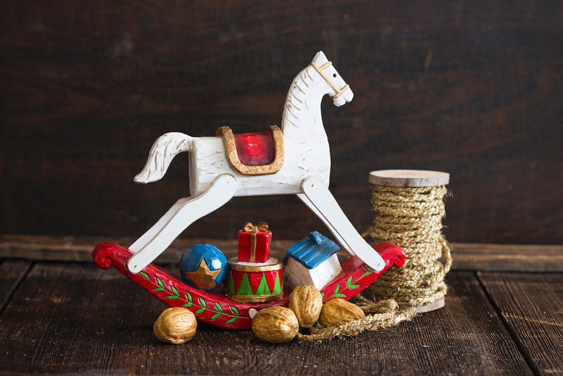 Kleines Holzschaukelpferd mit Nüssen als Weihnachtsdeko