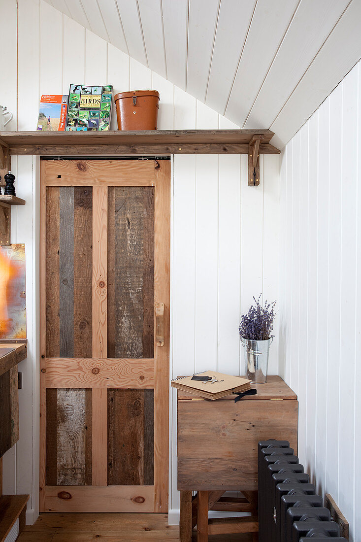 Sliding door made from reclaimed wood in tiny house with wood-panelled walls
