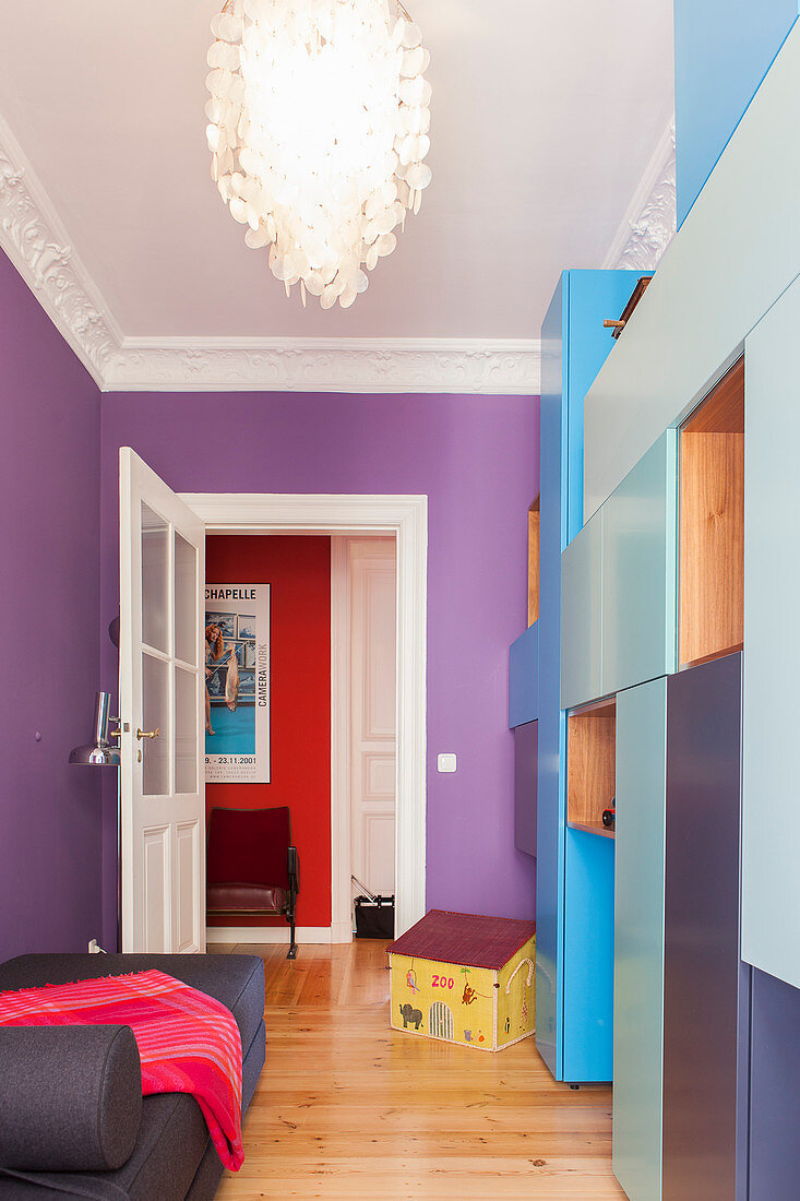 Schrankmodule in Blautönen im Gästezimmer mit violetter Wand