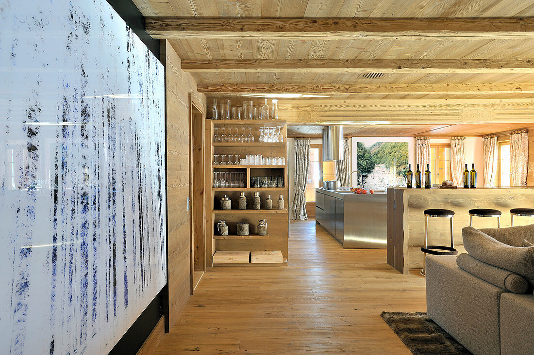 Großer offener Wohnraum mit Holzdecke und offener Küche