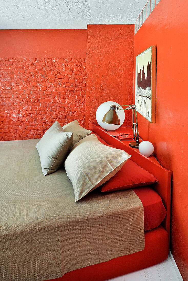 Double bed in bedroom with red-painted walls