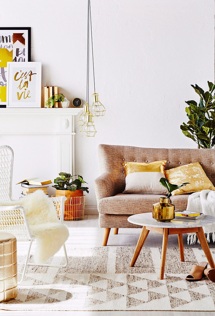 Sofa, Coffeetable und Outdoor-Stuhl im Wohnzimmer mit goldfarbenen Accessoires