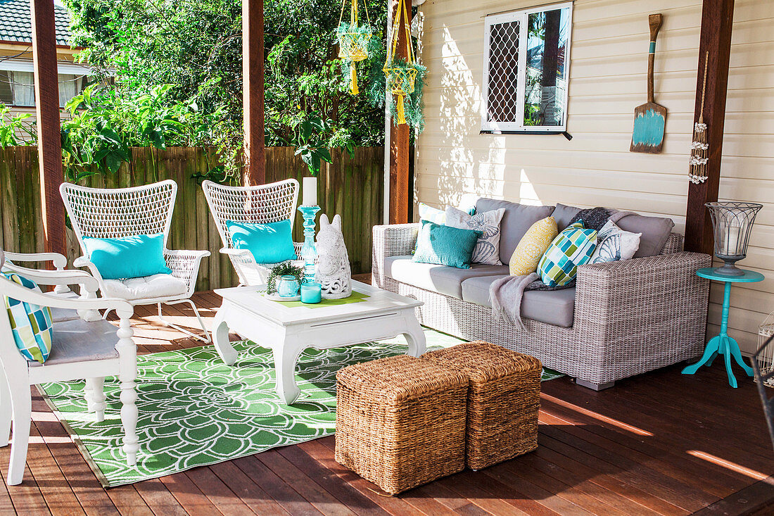 Sitzmöbel mit Kissen und Couchtisch auf wohnlicher Terrasse