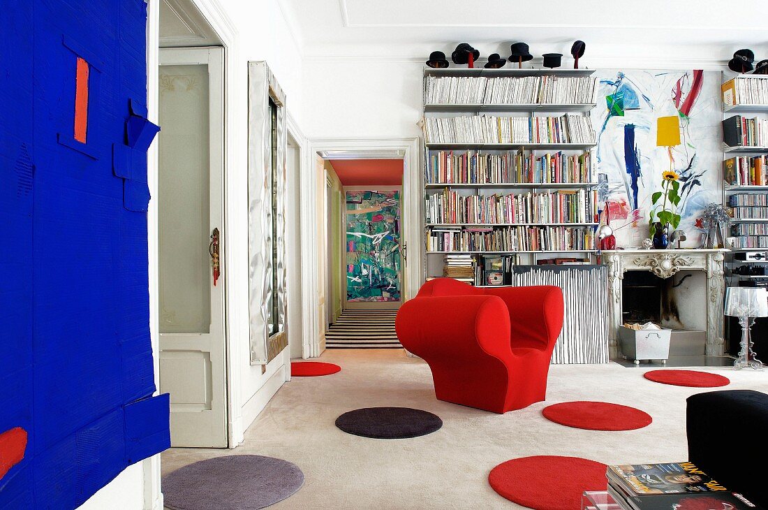 Eklektisches Wohnzimmer mit runden Teppich-Vorlegern, rotem Armlehnsessel und traditioneller Kaminverkleidung