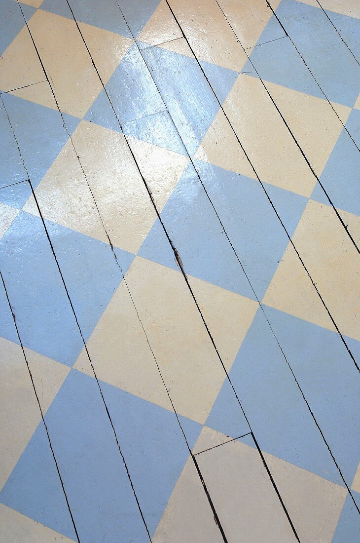 Weißer Dielenboden mit aufgemaltem Schachbrettmuster in hellblau