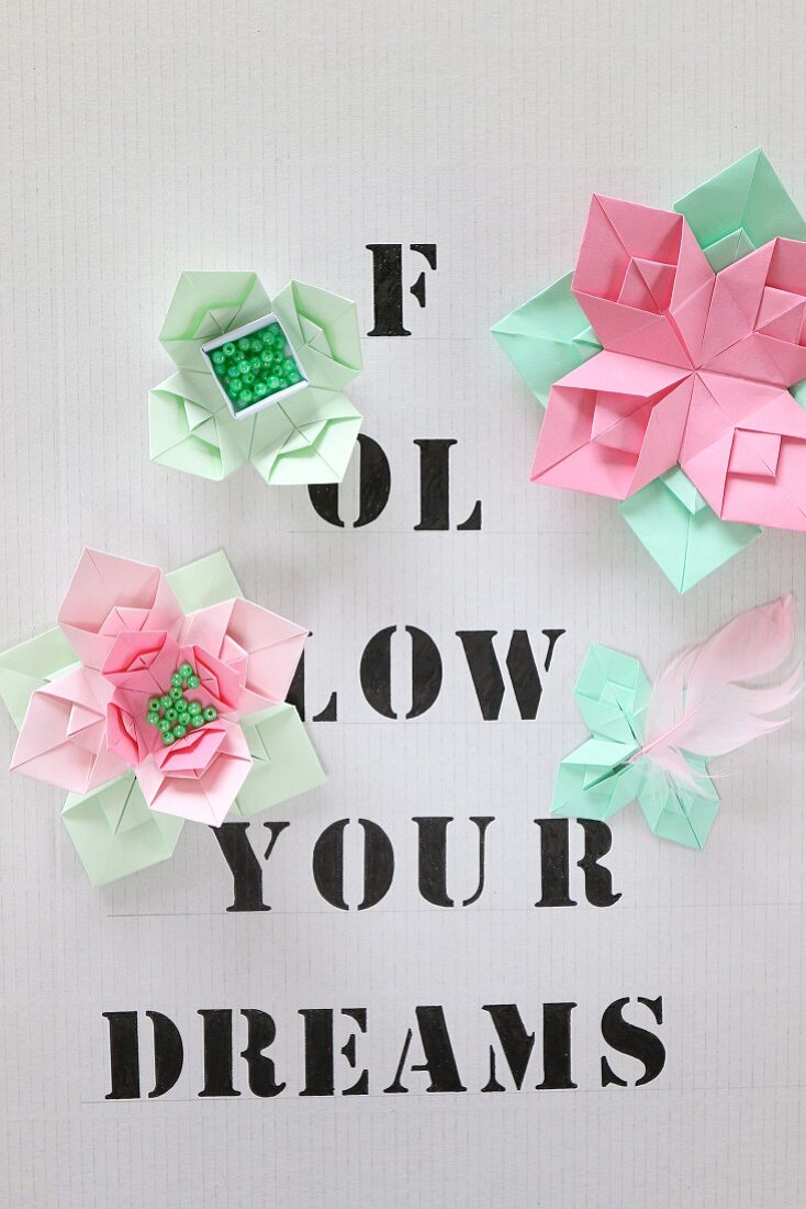 Origami flowers on paper printed with lettering