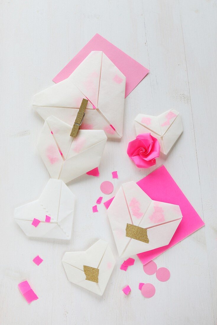 Translucent origami hearts with pink paper confetti