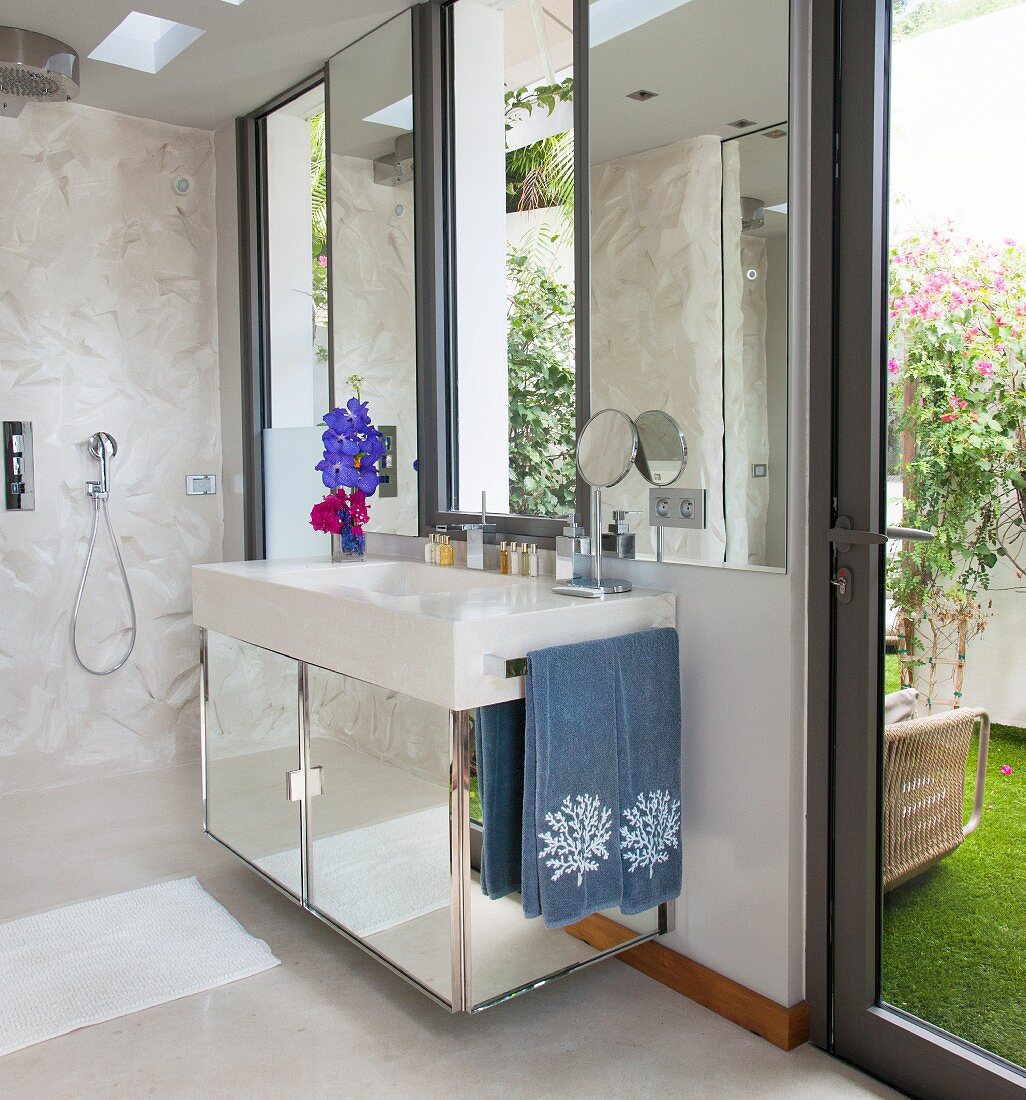 Mirrored washstand and doorway leading outside in bathroom