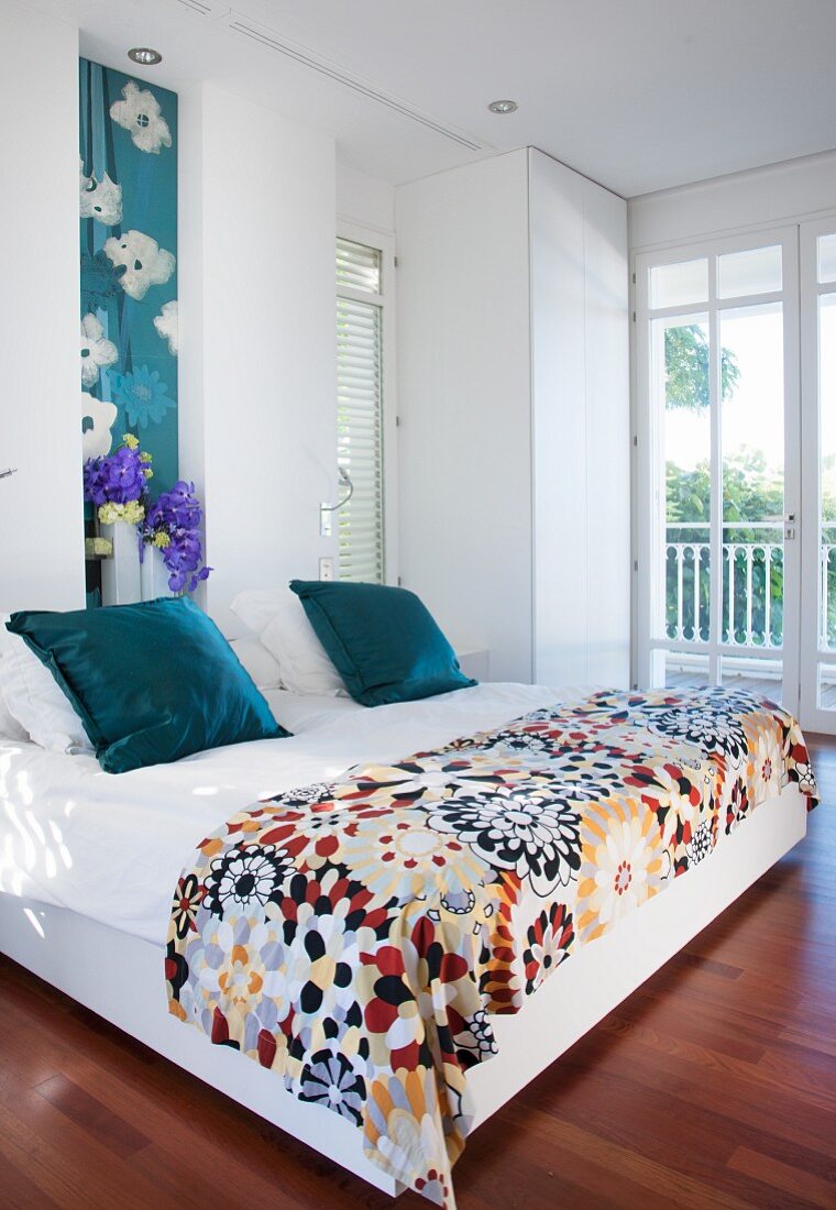Wooden floor and floral patterns in cheerful bedroom