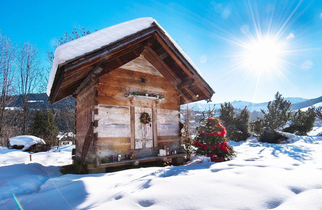 Kleine Holzhütte in verschneiter Winterlandschaft