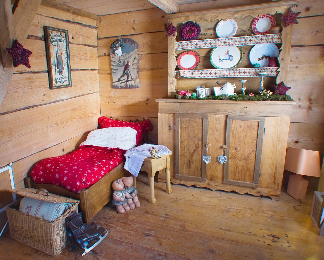 Small bed in festively decorated wooden cabin