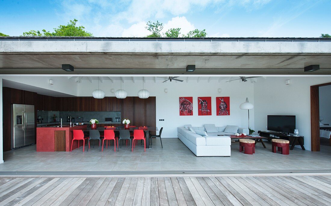 Blick in ein modernes Haus mit offener Wand zur Terrasse