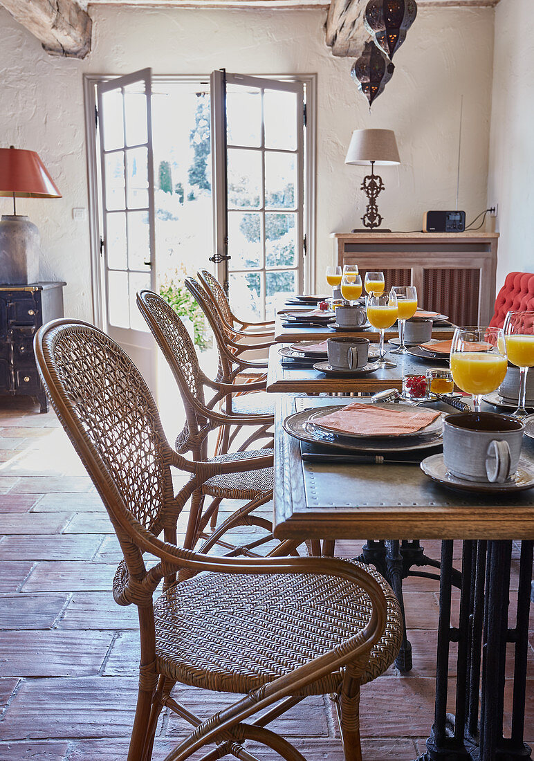Tables set for breakfast and vintage cane chairs in dining room