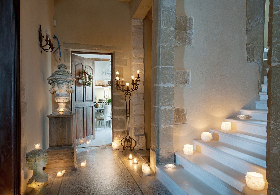 Foot of staircase with many lit candles in historical building