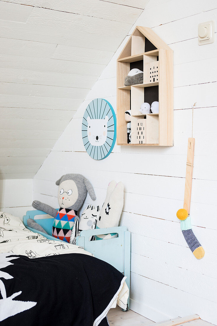 Display case on white-painted wooden wall in child's attic bedroom