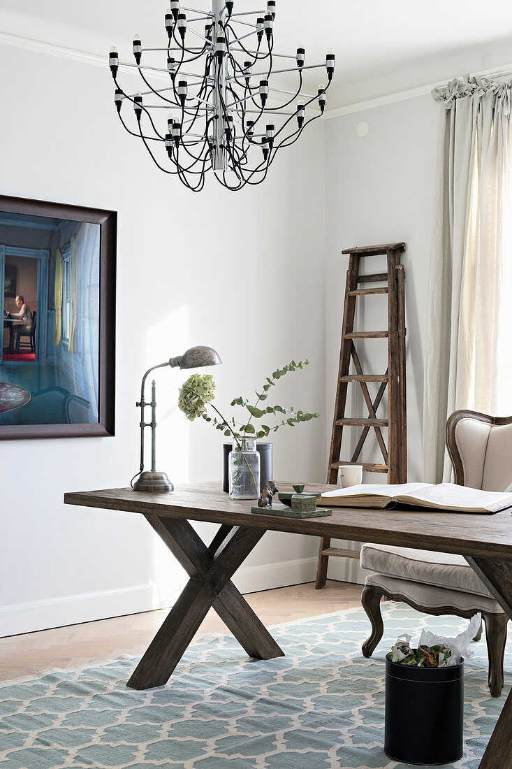 Elegantes Arbeitszimmer mit Holztisch und Kronleuchter