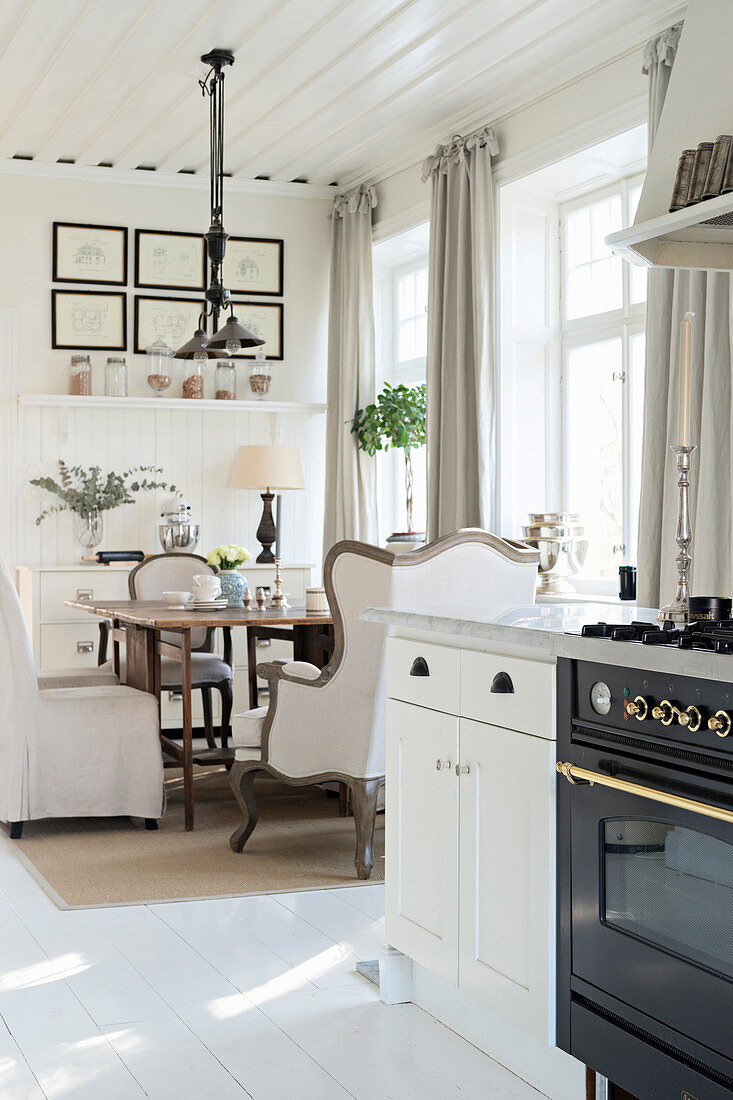 Wohnküche im eleganten Landhausstil mit weißem Holzboden
