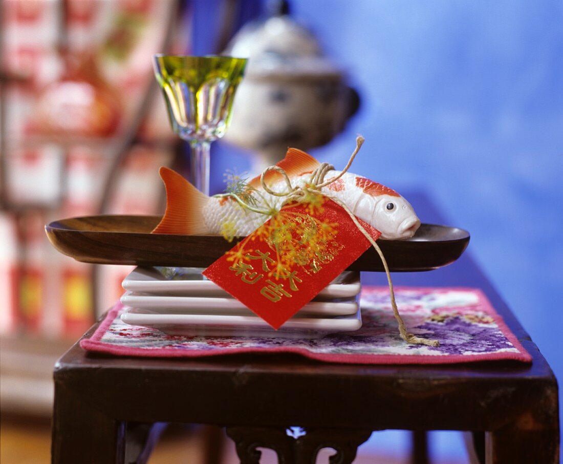 Plastic koi and Japanese tag on wooden tray
