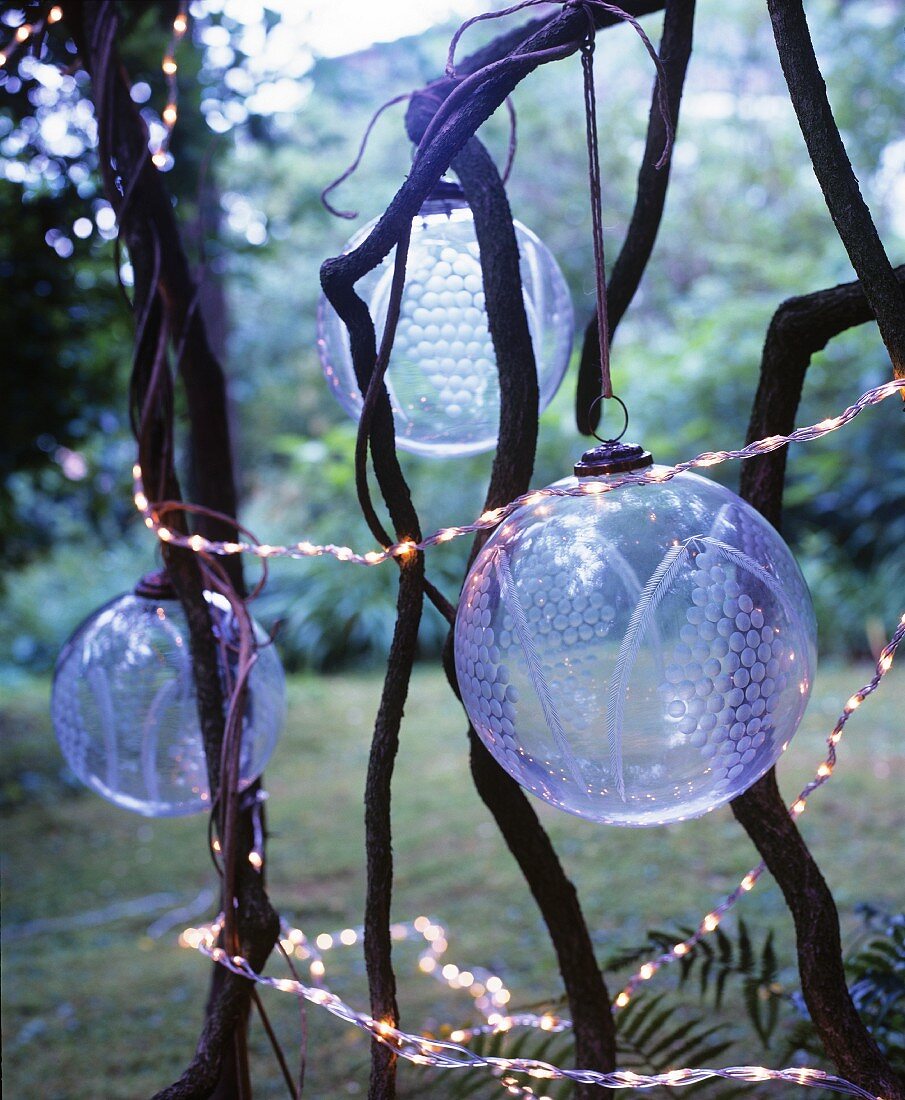 Transparent, patterned glass baubles and fairy lights hung amongst branches