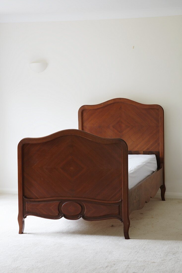 Antique bed with wooden veneer, headboard and foot