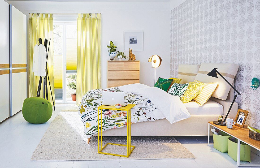 A springlike bedroom with double bed, different lamps and storage space