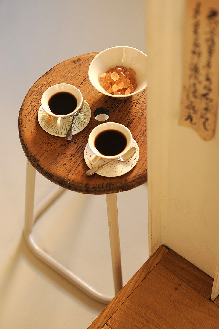Zwei Tassen Kaffee und Zuckerschale auf Retro Hocker