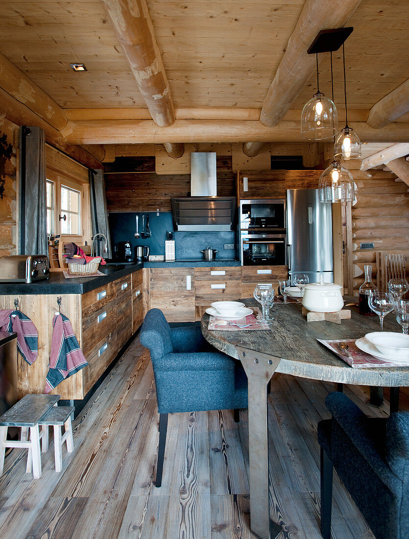 Gedeckter Tisch vor der offenen Küche mit Holzfronten im Blockhaus