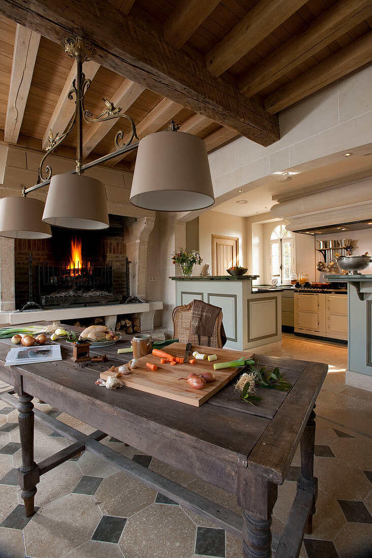 Rustikaler Holztisch in traditioneller Küche mit offenem Kamin