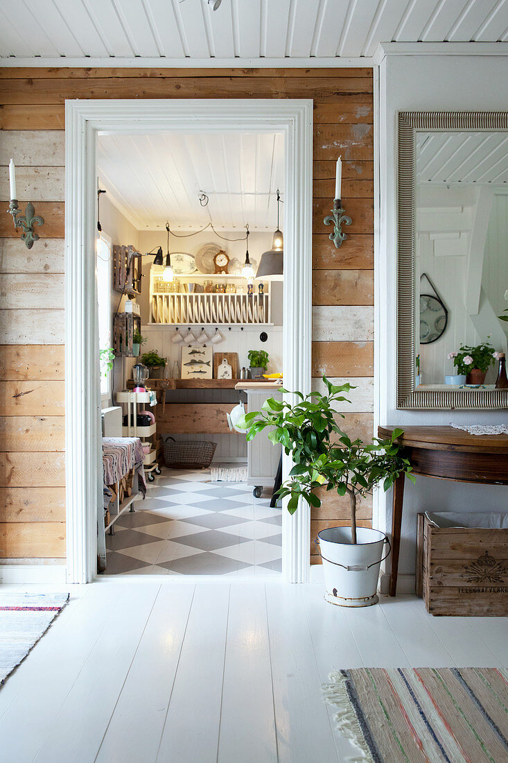 View from hallway with rustic board wall into country-house kitchen