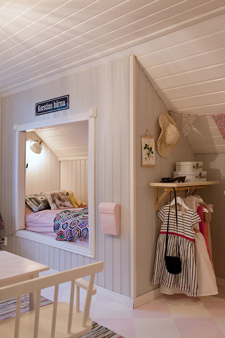 Cubby bed below sloping ceiling in child's bedroom