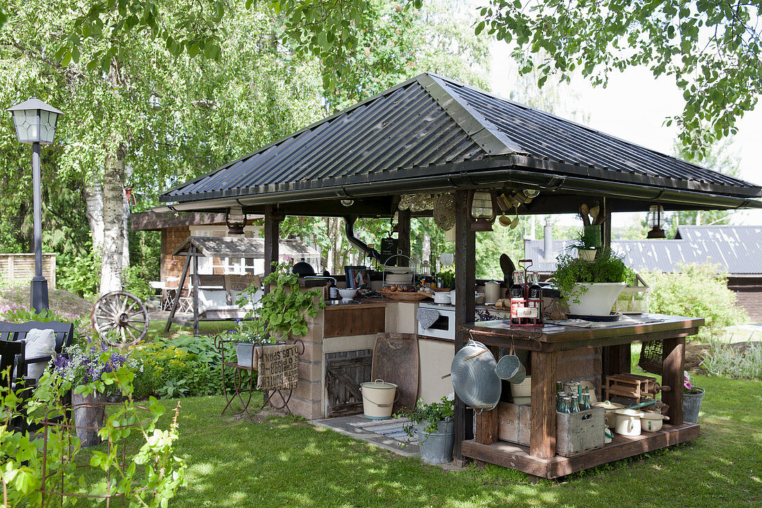 Überdachte Outdoor-Küche im sommerlichen Garten