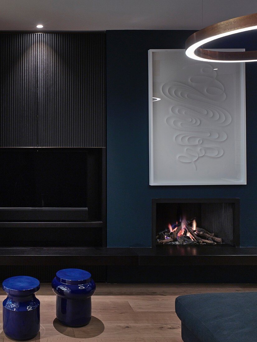 Open fireplace in dark blue and black living room