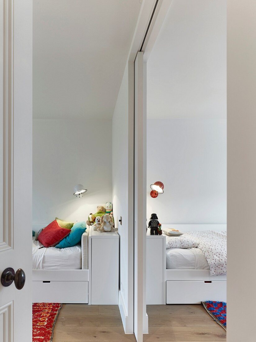 Beds with storage drawers in children's bedrooms separated by sliding doors