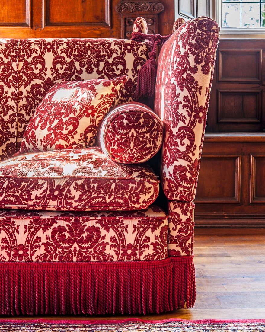 Classic sofa with red and white ornamental pattern and fringed trim