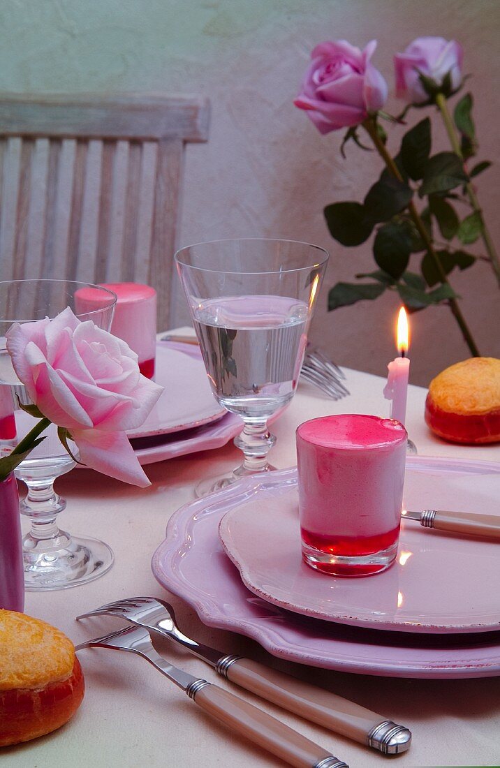 Pinkfarbenes Dessert auf romantisch gedecktem Tisch